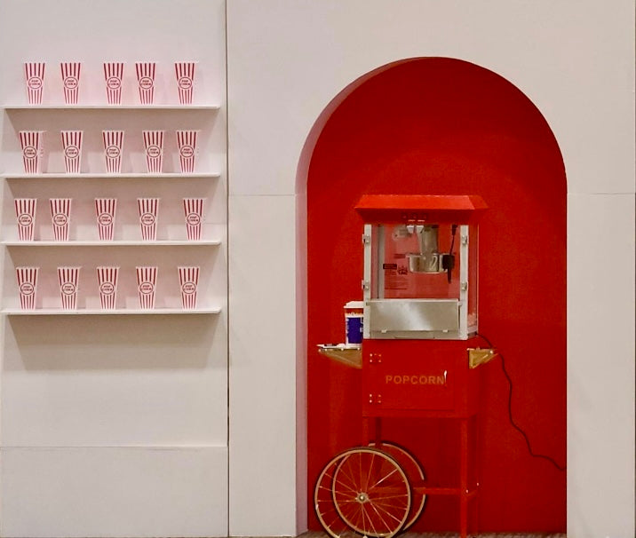 Popcorn wall backdrop with popcorn machine and shelves