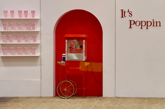 Popcorn wall backdrop with popcorn machine and shelves